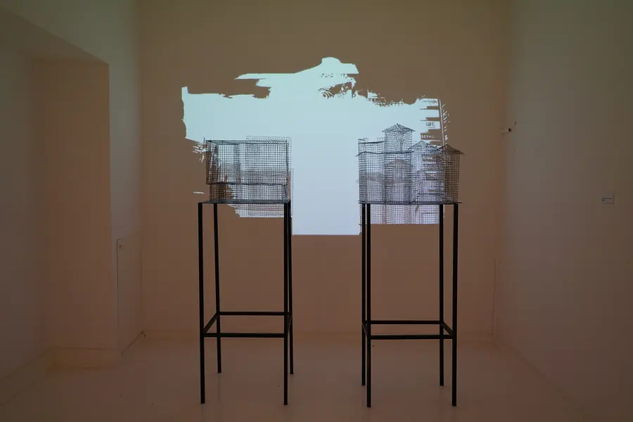 Two grid structures on tall stands in front of a wall projection