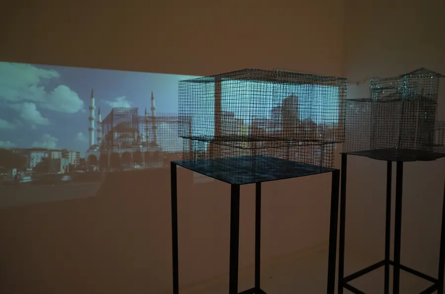Grid structures on stands with a projected city skyline behind them