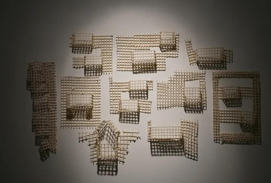Wall installation of small grid-like ceramic house fragments