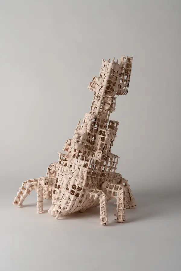 Ceramic grid sculpture with leg-like supports on a white background