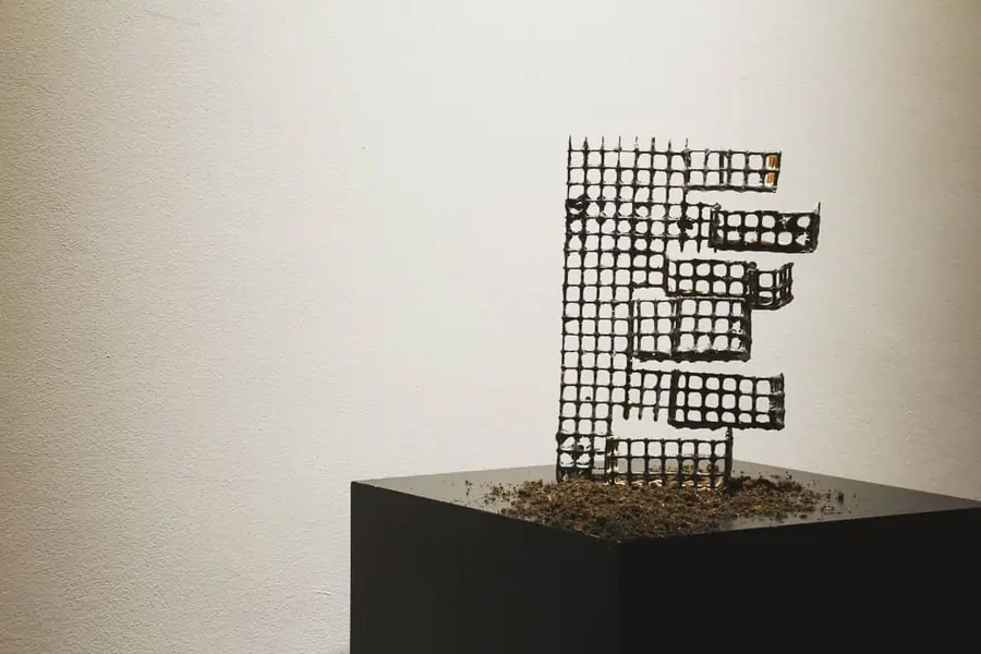 Grid sculpture standing on a black plinth