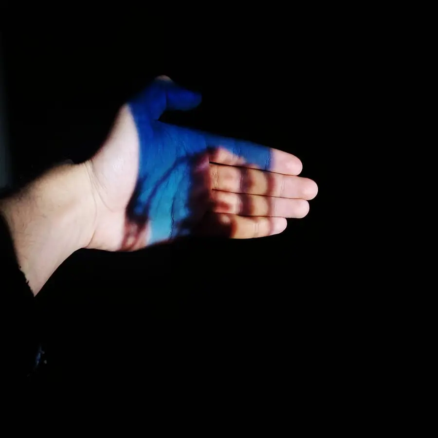 Open hand with a blue projection falling across it
