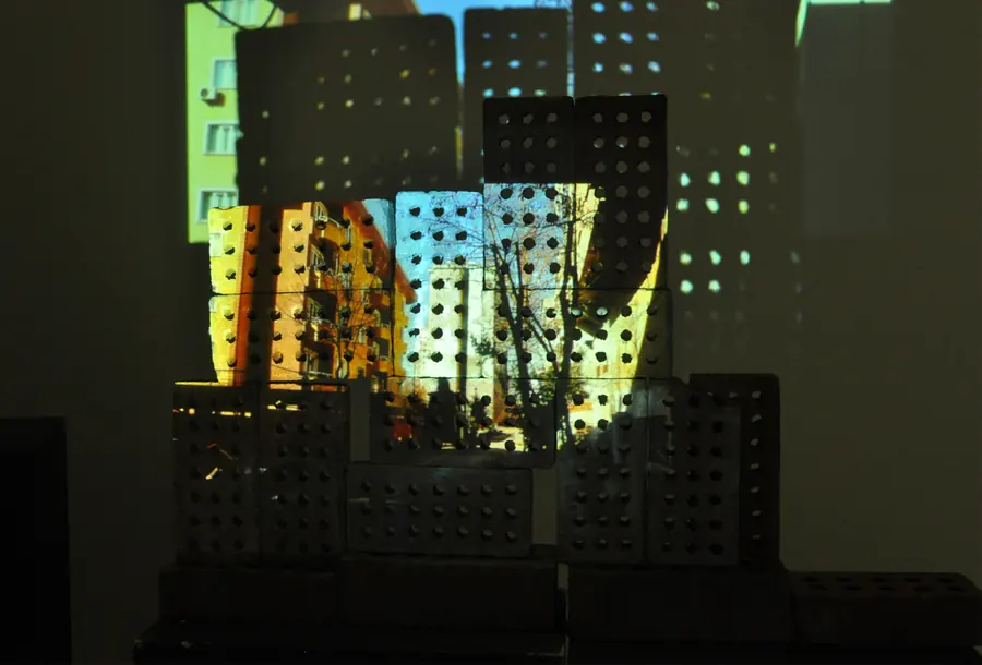 Coloured city image projected over perforated ceramic blocks