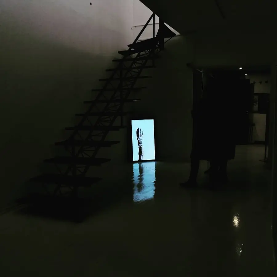 Dark staircase with a glowing screen at its foot