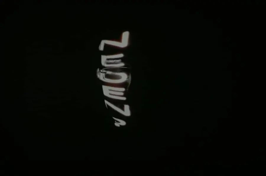 Distorted projected text on a black background